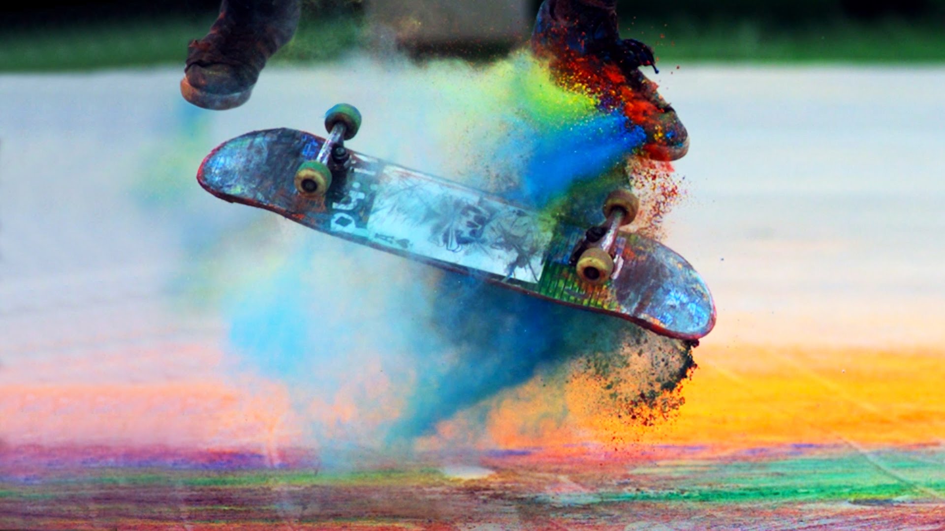 A skater doing a kickflip with colorful powder on the board.